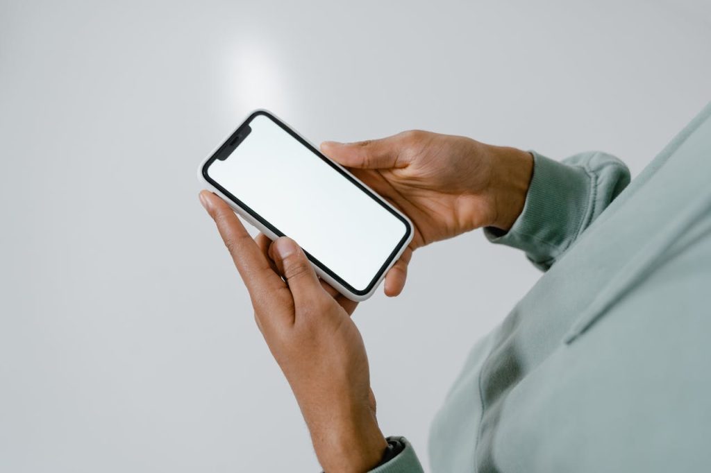 Close-up of hands holding a smartphone with a blank screen, suitable for mockups.